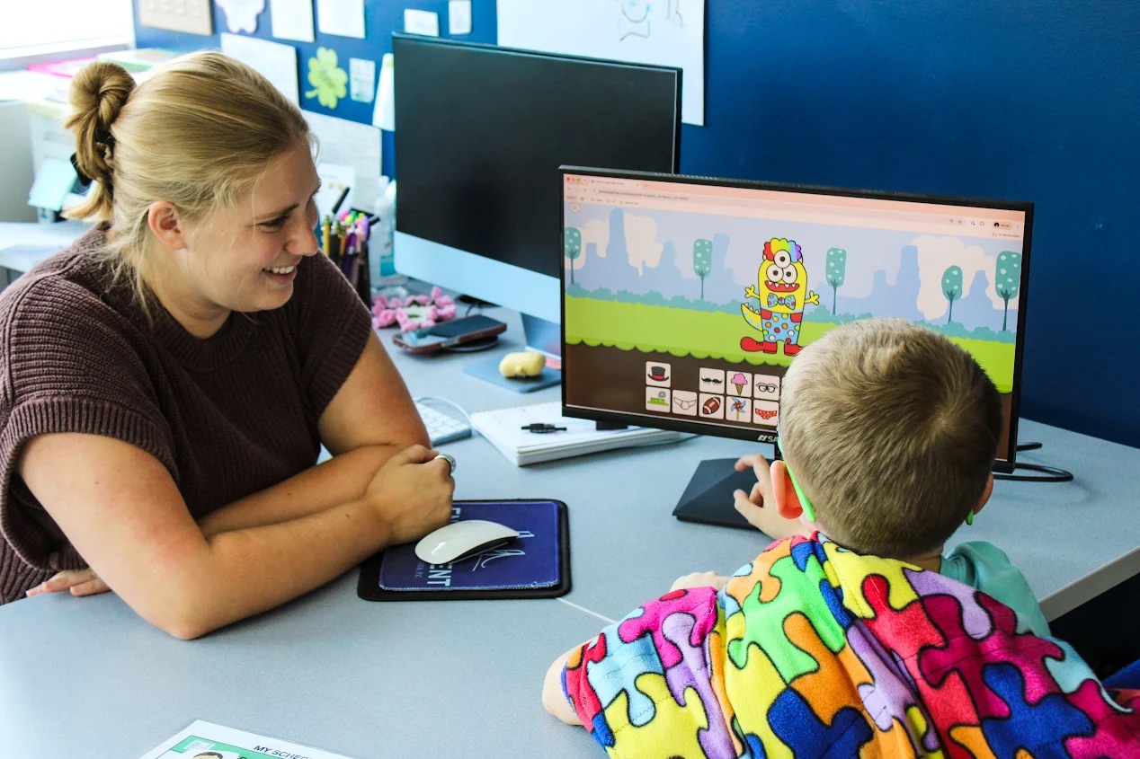Therapist and young child using an interactive digital game during a speech therapy session at ETLC