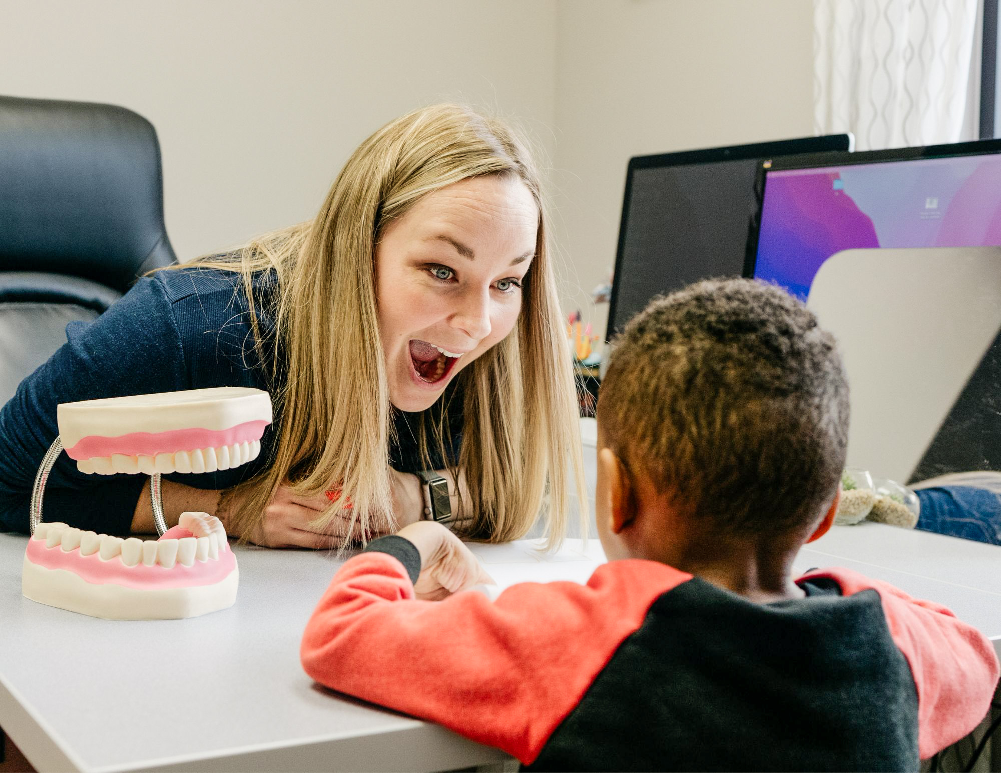 Young boy pointing to a card matching activity while working with a therapist using a visual timer