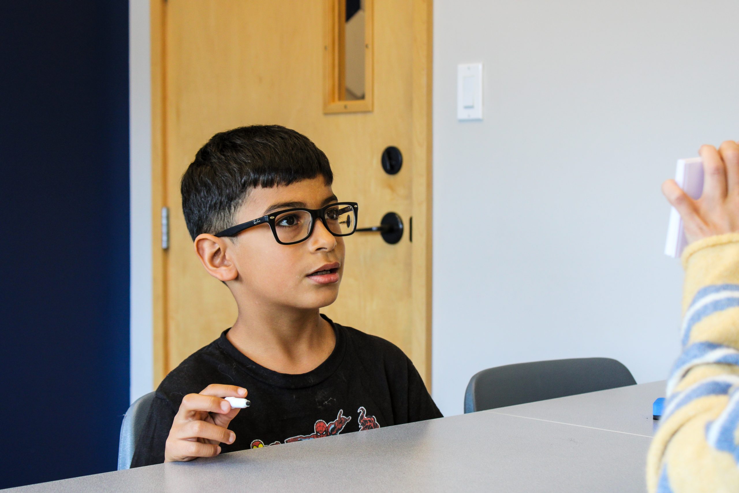 Therapist and young girl smiling while playing with alphabet blocks at a table