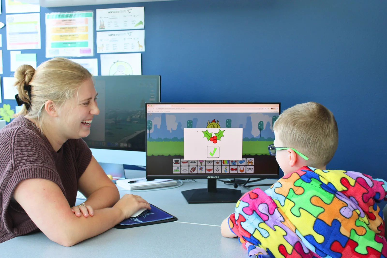 ETLC therapist and a young boy at a computer discussing healthy screen time habits