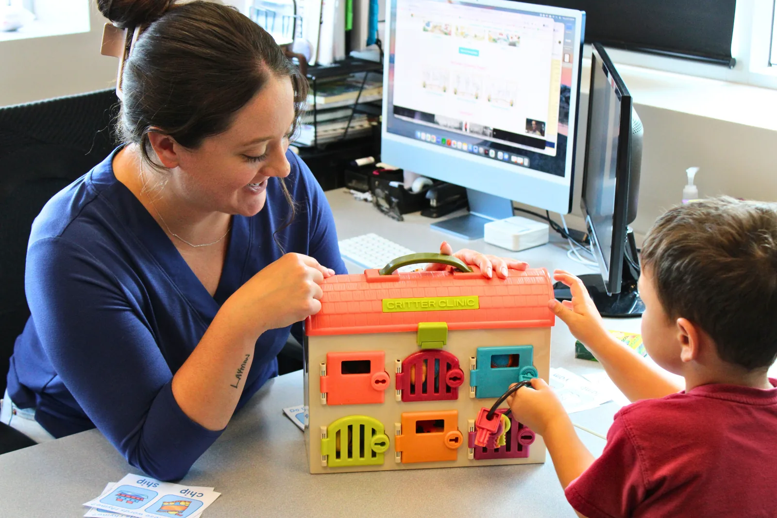 ETLC therapist using a latch-and-lock activity toy to practice following directions with a toddler