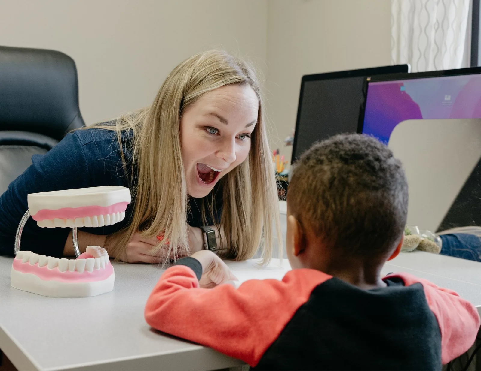 ETLC therapist using an oral anatomy model to demonstrate tongue placement to a child